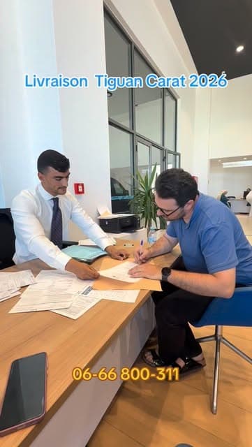 Anas Karmoun signe le dossier de livraison d'un Tiguan Carat 2026 avec un client